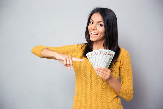 Vrouw wijzende vinger op dollarbiljetten