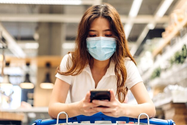 vrouw winkelen en smartphone gebruiken in de winkel