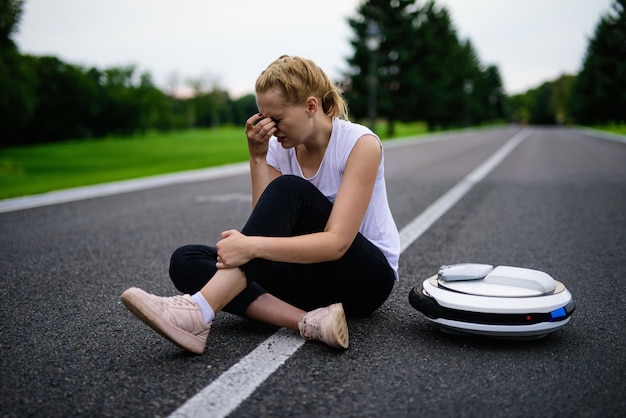 Vrouw wrijft gekneusd been. Boos meisje op de weg zitten.