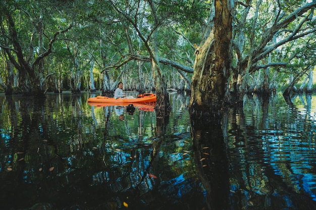 Vrouw zeilen zeekajak bij mangrovebos kanaal