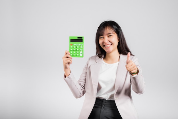 Vrouw zelfverzekerd glimlachend met elektronische rekenmachine en duim opdagen voor een goed gebaar