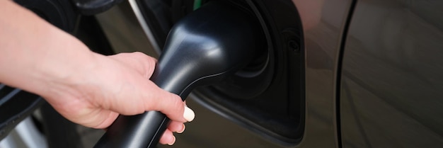 Vrouw zet brandstofspuitmond op benzinestation om auto met diesel te tanken