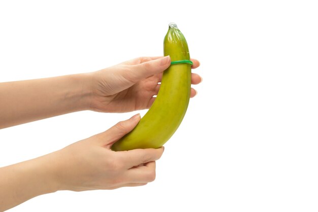 Vrouw zet een condoom op een banaan Geïsoleerd op witte achtergrond