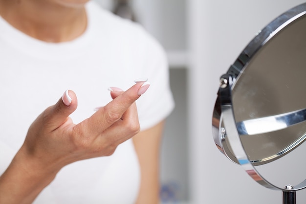 Vrouw zet een contactlens op voor zichtcorrectie