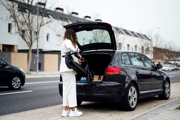 Vrouw zet elektrische scooter in auto