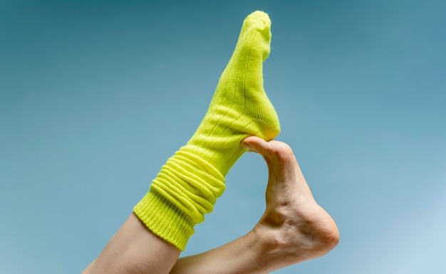 Foto vrouw zet groene sokken op haar voeten. geïsoleerd op witte achtergrond