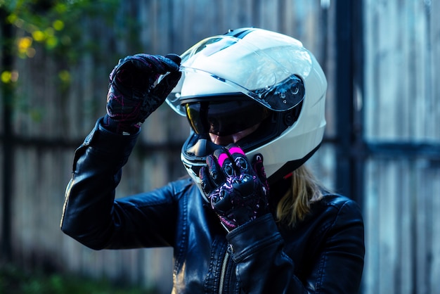 Vrouw zet motorhelm op en sluit gesp