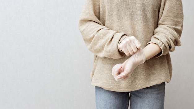 Vrouw zet rubberen handschoenen aan om haar handen te beschermen