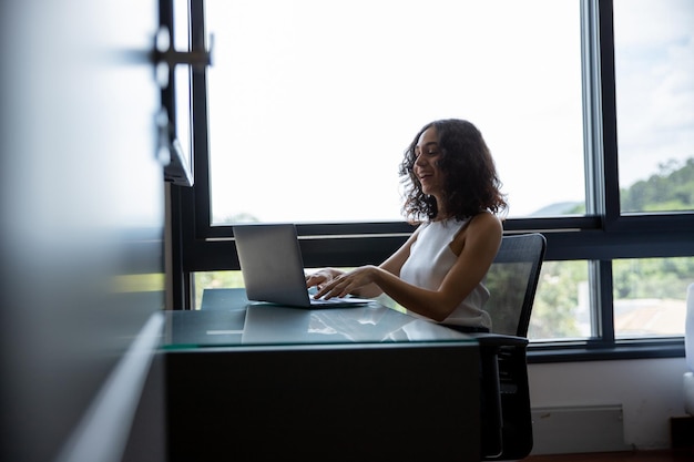 vrouw zit achter haar computer, vrouw werkt vanuit kantoor aan huis, student en haar computer, bijv