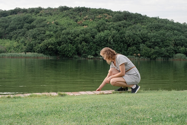 Vrouw zit bij het meer en kijkt weg