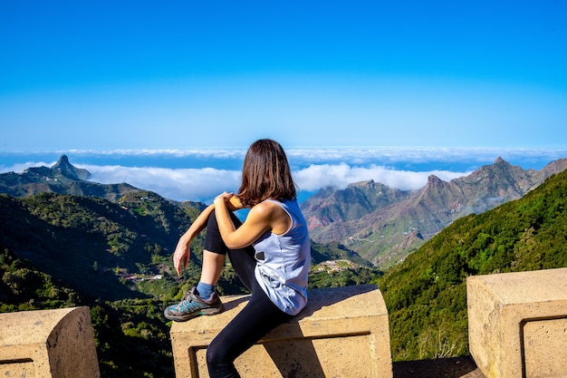 Vrouw zit boven de prachtige bergen in Tenerife, natuurpark Anaga in Spanje