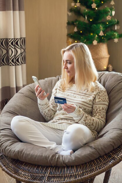 vrouw zit en betaalt voor online aankopen met creditcard met behulp van laptop en smartphone.