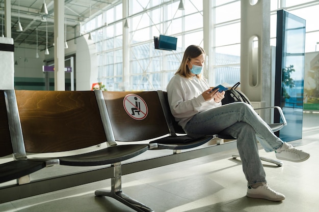 Vrouw zit in de luchthavenlounge en kijkt naar haar paspoort