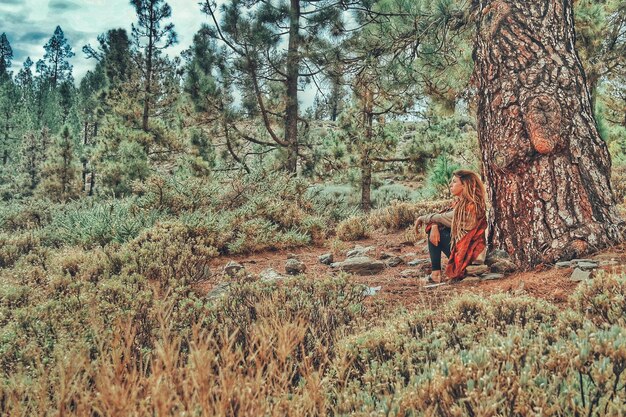 Foto vrouw zit in het bos.