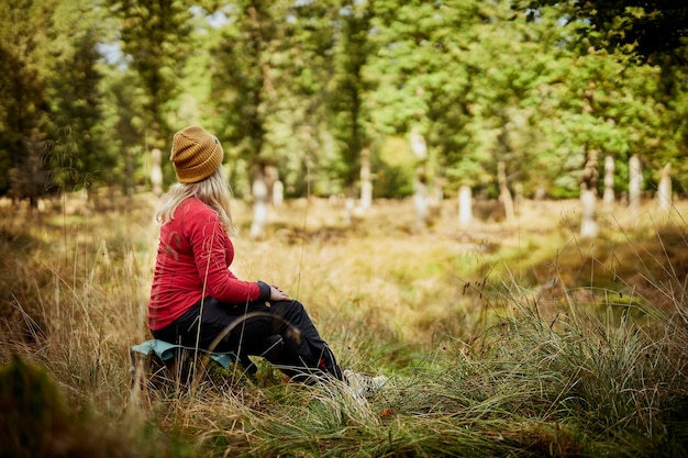 Vrouw zit in het bos