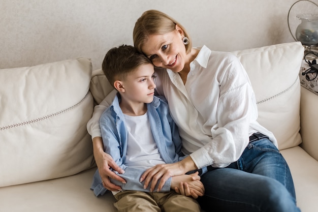 Vrouw zit met een tiener knuffelen en glimlachen