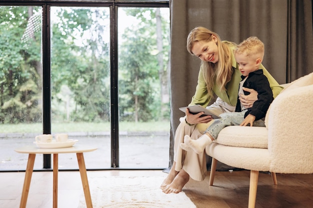 Vrouw zit met haar zoon en speelt op een tablet