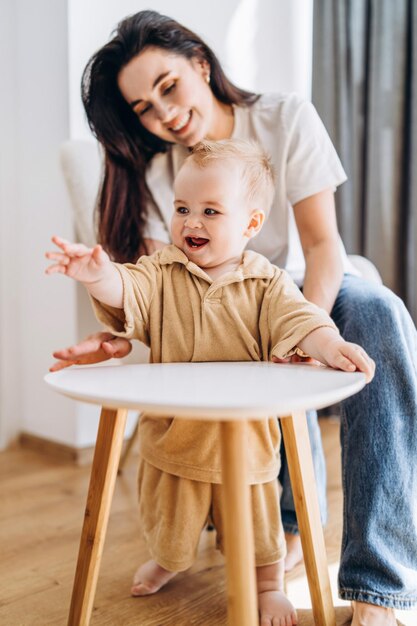 Vrouw zit naast baby in een hoge stoel