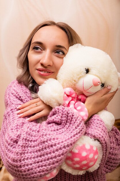 Vrouw zit op de bank met een teddybeer Retro foto met pluche speelgoed