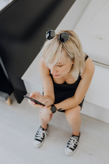 Vrouw zit op de trap en speelt op haar telefoon