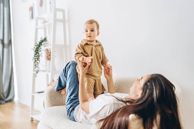 Foto vrouw zit op een bank met een baby in haar hand