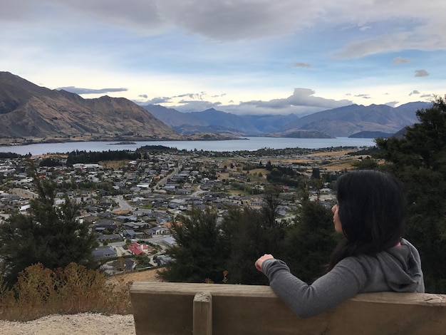 Foto vrouw zit op een bankje tegen het stadsbeeld