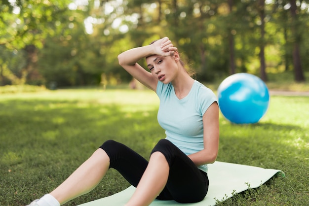 Vrouw zit op een tapijt voor yoga en rusten.