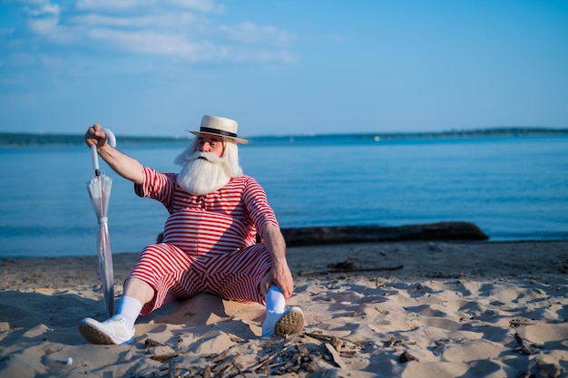 Foto vrouw zit op het strand bij de zee tegen de lucht