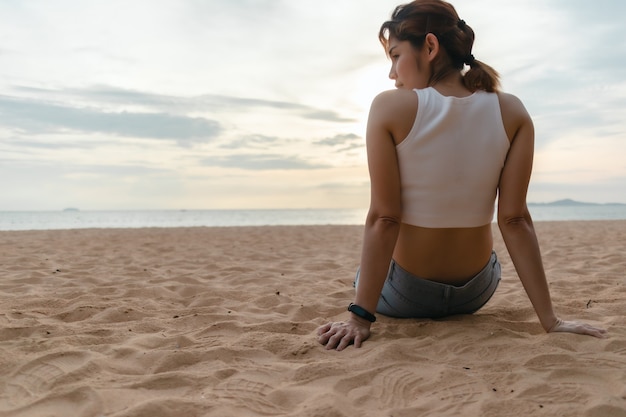 Vrouw zit op het strand in de zomer