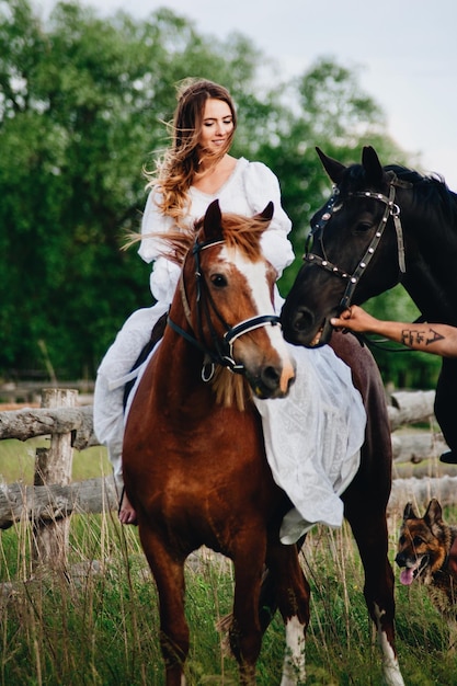Vrouw zit op paard tegen een boom.