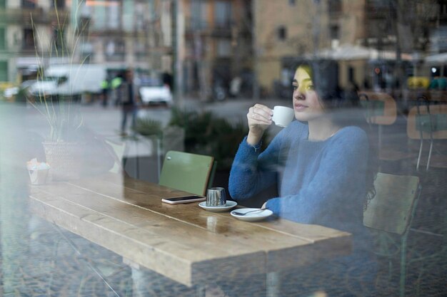 Foto vrouw zit op tafel in een café in een restaurant