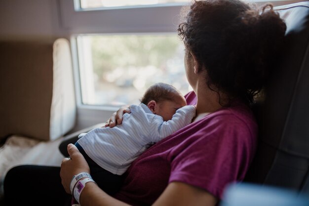 Foto vrouw zit thuis met haar pasgeboren zoon.