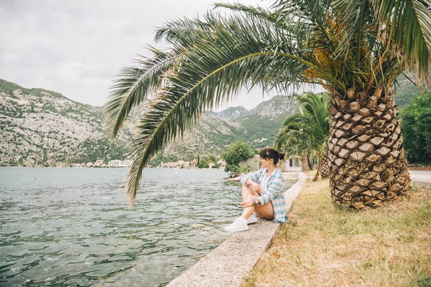 Vrouw zitten aan zee kijken naar golven bergen op background