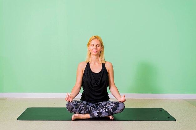 Vrouw zitten en het beoefenen van yoga in de studio