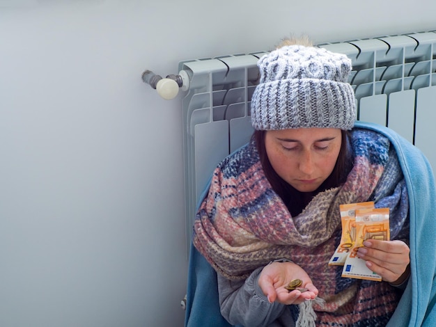 Foto vrouw zitten en tellen van eurobankbiljetten in de buurt van de batterij