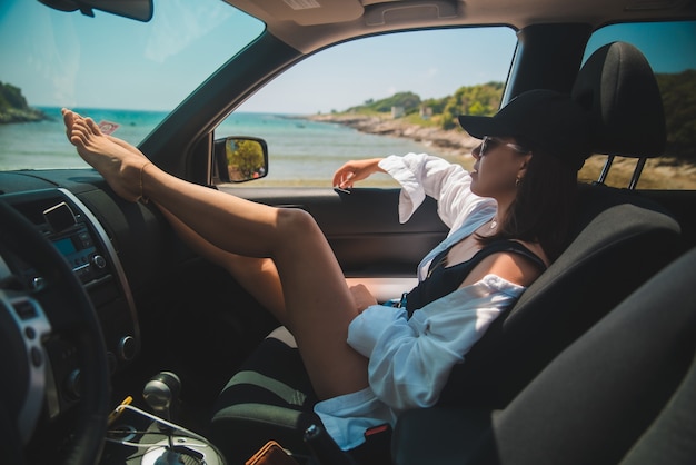 Vrouw zitten in auto show sexy benen kijken naar zomer zee strandvakantie