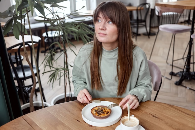 Vrouw zitten in café en cake eten