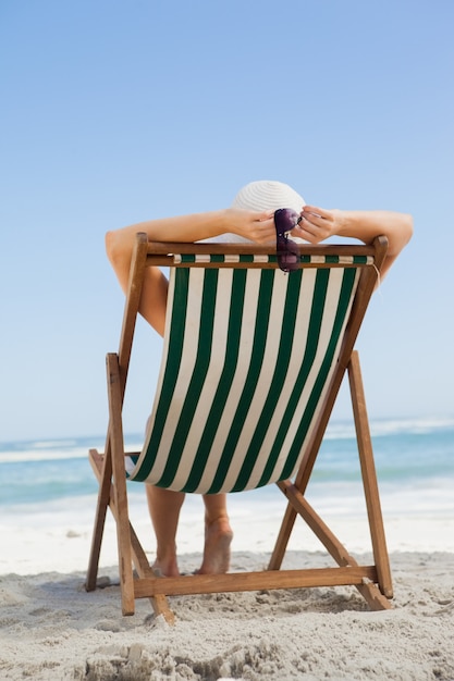 Vrouw zitten in de ligstoel op het strand