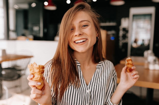 vrouw zitten in een café met strepen overhemd poseren