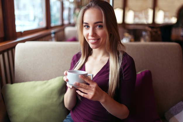 Vrouw zitten in het café met een kopje drank