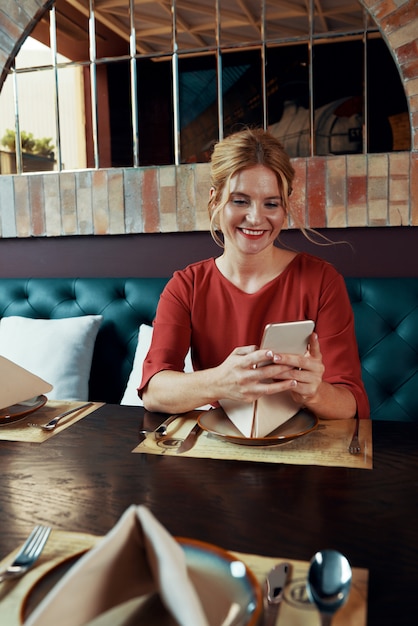 Vrouw zitten in restaurant en sms'en