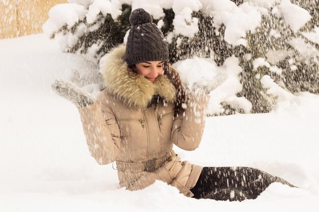 Vrouw zitten in witte sneeuw in winter park