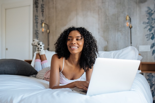 Vrouw zitten op bed op de computer