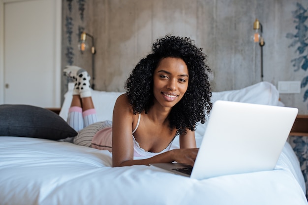 Vrouw zitten op bed op de computer