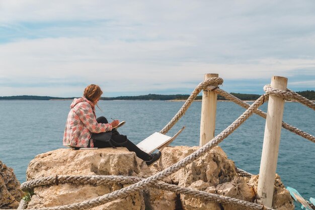 Vrouw zittend aan de rand tekening afbeelding van zeegezicht