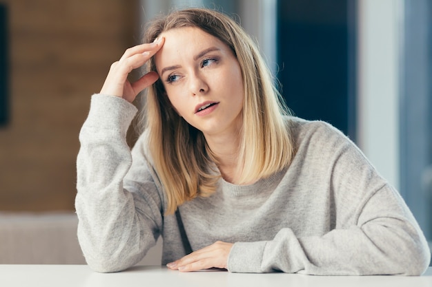 vrouw zittend aan een tafel op kantoor hevige pijn