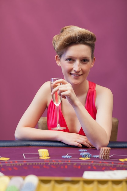 Vrouw zittend aan tafel terwijl een glas champagne