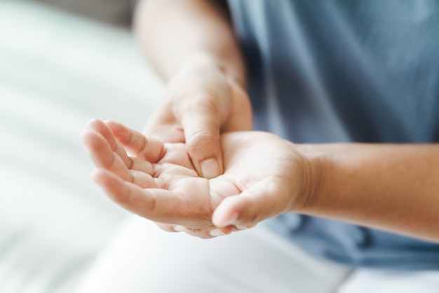 vrouw zittend op de bank houdt haar pols handletsel pijn voelen Gezondheidszorg en medisch concept