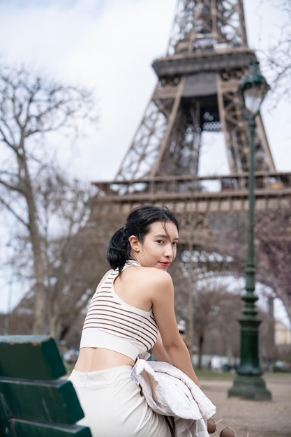 Vrouw zittend op de bank in de buurt van de Eiffeltoren Parijs Frankrijk