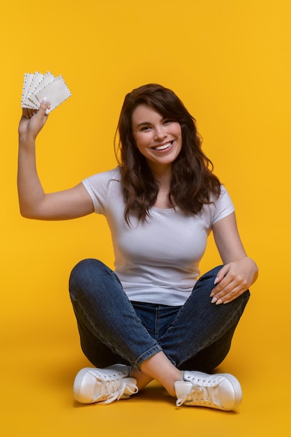 Vrouw zittend op de vloer met letters in opgeheven hand